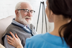 Camera view looking over the shoulder of nurse consulting a patient