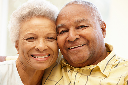 Couple smiling in warm embrace with their heads leaning on each other